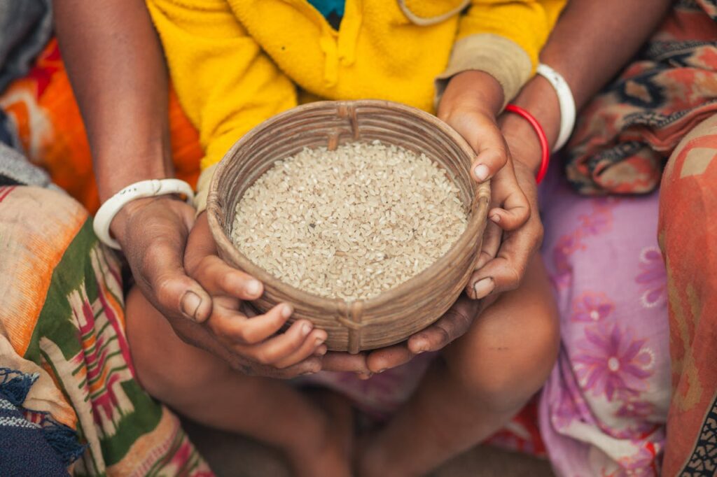Close-up of hands holding a woven basket filled with rice in Bangladesh.